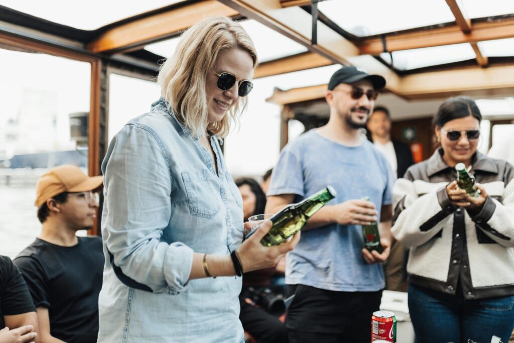 A group of friends having fun on a boat with drinks, enjoying leisure time together.